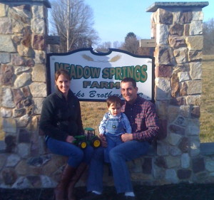 Jamie Hicks (from left) sits with his son, Graham, and wife Kate at the entrance to Meadow Springs Farm on East Doe Run Road.