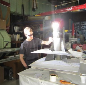 Jason Silverman works in a USC  lab under bright lights that help cure the epoxy that is applied to the rocket. 