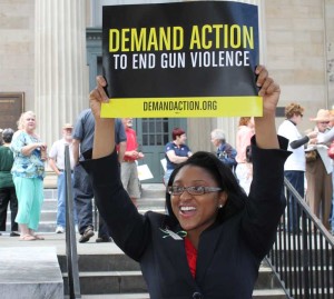 A supporter of universal background checks for gun purchases holds her sign at a rally, Friday, to commemorate the six-month anniversary of the school shootings in Newtown Square, Connecticut. The event, one of many across the state was organized by Mayors Against Illegal Guns and local community groups.