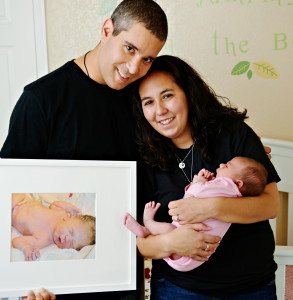 Shane Brant and his wife, Suzanne Campos, pose with their daughter, Alex, now 9 months old, and a photo of their son, Max Athan Brant, whose legacy is helping other children.
