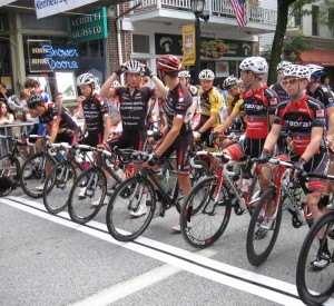 Garneau-Quebecor team clinches overall victory as large crowd looks on By Steven Silverman, Correspondent, The Times The pro racers ready their equipment before beginning the race.     The pro racers line for the start of Saturday's Chesco Gran Prix in Kennett Square. A large crowd enjoyed cycling, food and fun at the race's final stage. KENNETT SQUARE — The center of the borough echoed with the cheers from hundreds of enthusiastic spectators Saturday night as the Kennett Square Criterium and Chesco Grand Prix drew to a close. From the various amateur and kids’ races in the early afternoon to the intense pro race in the evening, the night was packed with excitement and enjoyment. The favored Garneau-Quebecor team clinched its overall victory in the pro race, with members Adam Farabaugh and Zach Hughs finishing first and second, respectively. Farabaugh managed to go an entire lap up on the peloton, or main field, while Hughs edged Skyline’s Ryan DeWald in a sprint for second. In the Category 3 race, Vincent Reydams of the World Cup Ski & Cycle Racing Team took the win after Luke Lukas, who had a 20-second lead on the field, crashed and was forced back behind the pack. Reydams edged three other riders at the line. Individual winner Adam Farabaugh (right) and runner-up Zach Hughs hold their Garneau-Quebecor overall team trophy.     Individual winner Adam Farabaugh (right) and runner-up Zach Hughs hold their Garneau-Quebecor overall team trophy. Martin Mrugal demolished the field in the 45-and-older race to win by a wide margin, while Nick Sears continued his dominance in Category 4, winning his fourth race in a row. Sears, who is a mountain biker at heart, noted that “the hill in the beginning kind of separated the field a bit…it was a good fit.” Mixed in with the competitive races were short kids’ races and even a local celebrity race. State Representative Chris Ross, Kennett Mayor Matt Fetick, and Portabello’s Restaurant chef Brett Hulbert were some of the participants who rode to show their support of the event. Most racers who had earlier events stuck around with their supporters as fans for the rest of the night. Everyone treated their mouths to delicious bites from streetside restaurants while their ears enjoyed rock music and the non-stop commentary of announcer Richard Fries. Announcer Richard Fries spurs on the competitors from the middle of the racecourse.     Announcer Richard Fries spurs on the competitors from the middle of the racecourse. Fries, who turned to announcing after his own short pro cycling career, has been covering events such as the World Road and Cyclocross Championships for 18 years. Mixing an insider’s knowledge and color commentary with an affable demeanor, he walked up and down the course chatting with spectators, advertising for local businesses that catch his eye, and gathering money for prime (pronounced “preem”) laps, in which the winner of the lap gets an extra prize. He complimented the Chester County towns that host the races, calling them “great little communities that bikes are a really important part of.” Fries noted that Chester County’s great mix of “hip little towns” and open country makes it remarkably like European cycling. The crowd became more and more excited as the evening wore on, spurred on by Fries’s constant exhortations and the Victory Brewing Company’s beer garden. The clouds looked threatening much of the night, but only a few drops fell. The winners were treated to an awards ceremony at the start-finish line afterwards, but proceedings wound down quickly: with the recreational Kinetic Chesco Tour Sunday, everyone wanted a good night’s sleep.