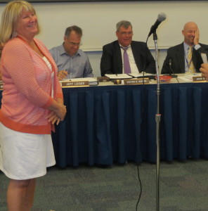 Sue Natale, who retired as an assistant in the district's technology department, listens as Josh Boughner, the network administrator, discusses the ways in which she will be missed.