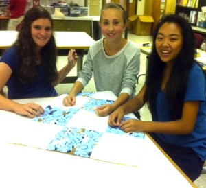 Patton students (left to right) Madyson McDougal, Rachel Ioele, and Cara Freedman work on a quilt to be donated to sick children at A.I. duPont Hospital.