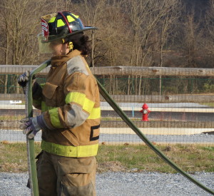 Seventeen-year-old Jordan Gusler straightens out a hose so that it can be rolled up.