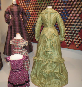 Two women's dresses, a  green striped silk and a purple and black plaid silk taffeta, and two child's dresses, a red, black and white plaid cotton and a magenta, black and white plaid wool with black velvet trim, were worn in Chester County in the 1860s and 1870s.  from 1869-1872 