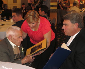 Mike DiPietro reads one of the commendations from local lawmakers held by his daughter, Lisa DiPietro, as Kennett Square Police Chief Edward A. Zunino Jr. prepares to hand him another one.