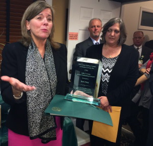 Elizabeth B. Pitts (left) explains why the 2013 John J. Crane Award means so much to her as attorney Dawson R “Rich” Muth, County Commissoner Kathi Cozzone, and Chief County Detective James Vito look on.