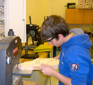 Jonathan Dembeck separates the router cut duck bodies using a band saw.