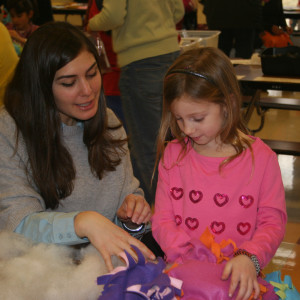 Malina Margolus (left) helps Chadds Ford Elementary Kindergartener Ava Robbins (right) craft a no-sew blanket to be donated to children in need.