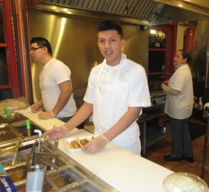 Armando Bernal (from left) takes an order as Daniel Castaneda puts toppings on a fish taco that Martha Rodriguez has just prepared at Michoacana Grill.