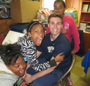 Fifth-grade Study Buddies participants Johnnette Boddy (from left), Jalayshia Allen and Aalana Vasquez gleefully surround their helper, Unionville High senior Clark Bingol.