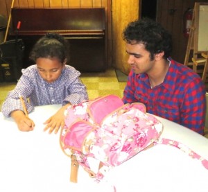 Unionville High junior Abu Akki oversees the work of 6-year-old Payton Myers-Corp during the Study Buddies after-school program.