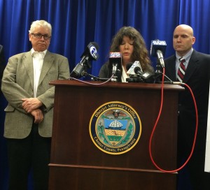 Pat Crowley (left) and District Attorney Tom Hogan listen as Diane Crowley addresses a news conference on increasing penalties for repeat drunk drivers who cause a death. The Crowleys lost their son, Liam James, a year ago, in a crash caused by an eight-time drunk-driver.