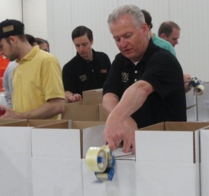 Wegmans Malvern Store Manager Jerry Shelly demonstrates his taping skills during the sorting of more than 18,000 pounds of food donated by his company.