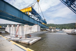 The I Lift NY super crane places an immense steel girder assembly on the new bridge's concrete piers.