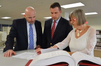 Chester County District Attorney Tom Hogan (left) and Chester County Recorder of Deeds Rick Loughery (center) reviewing a real estate transaction with Deputy Recorder of Deeds Ruth Huganir (right).