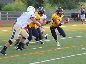 Unionville QB Alex Gorgone looks to evade Spring-Ford defenders — the junior QB had an uneven debut as a signal caller. Jim Gill photo.