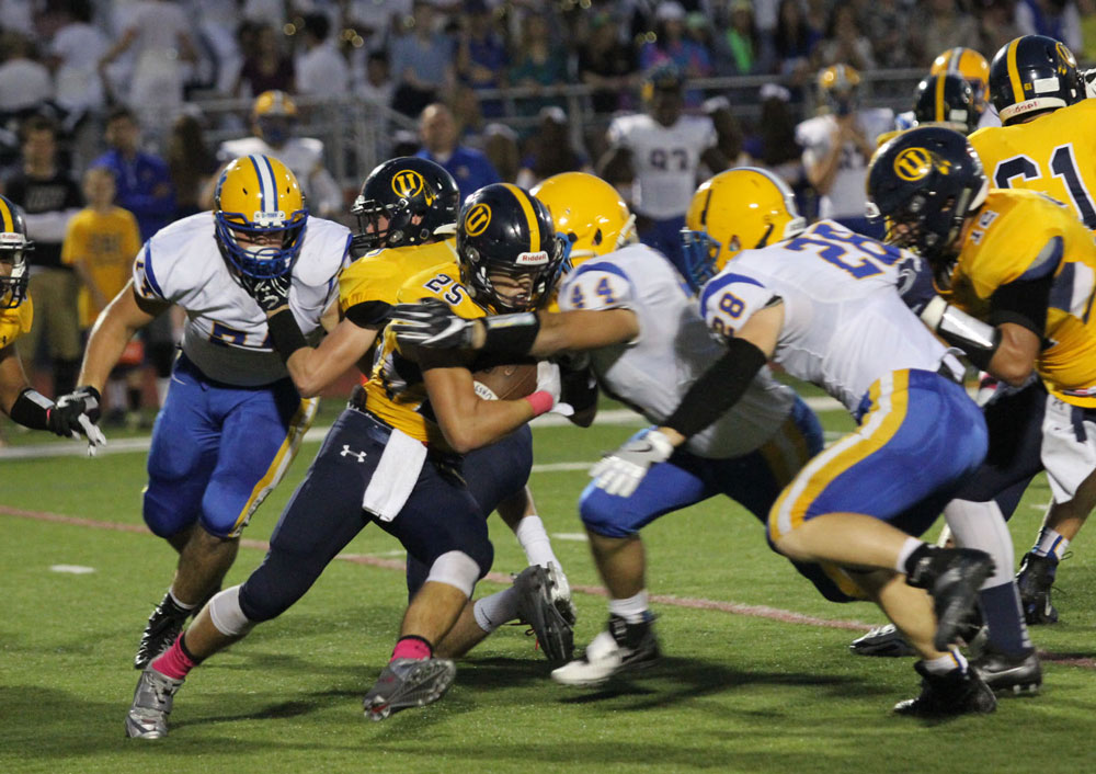 Downingtown East's dominant defensive line often was able to power through and stop run plays in the backfield against Unionville, Friday. Here, Stephen Dilulio (44) and Jack Hayward (28) close in on Jack Adams (25). Jim Gill photo.