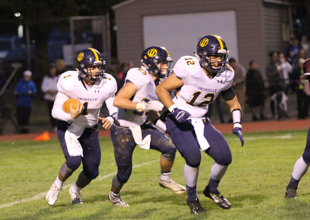 Unionville quarterback Joe zubillaga looks for running room behind Jack Adams (25) and chris D'Amico (12). Jim Gill photo.